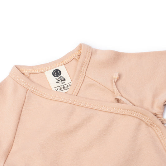 Newborn crossover bodysuit in dusty blush organic Egyptian cotton, detail view