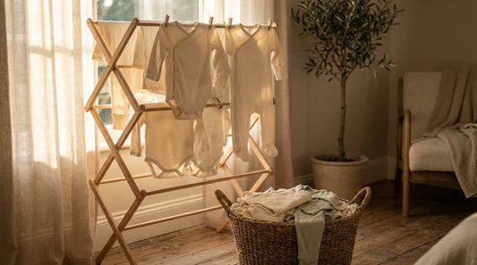Fresh baby clothes drying on rack in warm sunlight