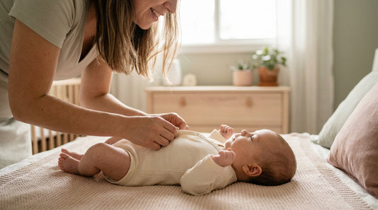 Mother gently dressing baby in soft organic cotton