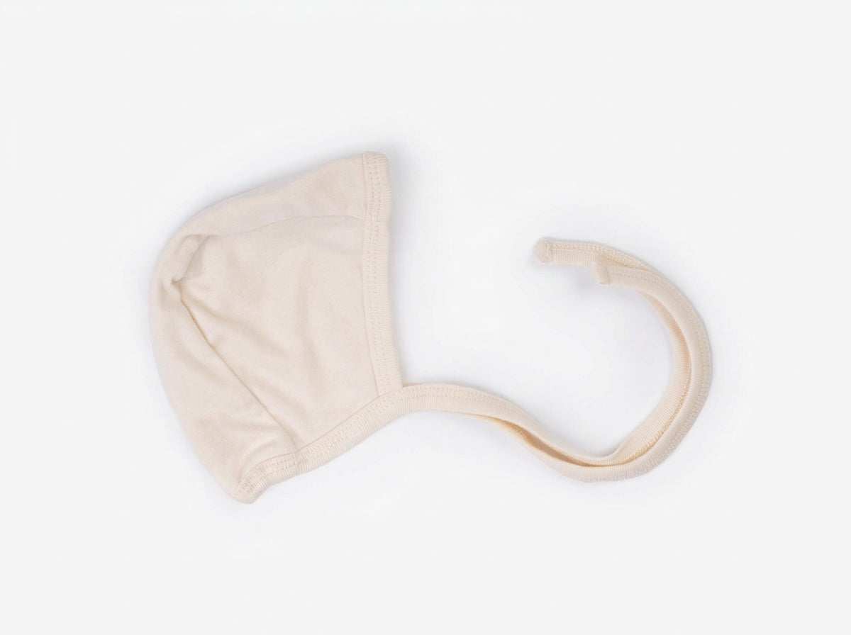 Plain Alabaster baby bonnet flat lay
