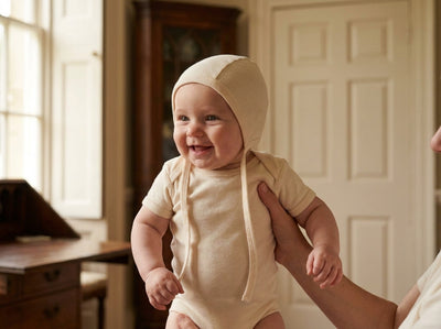 Baby wearing plain organic Egyptian cotton bonnet in Alabaster
